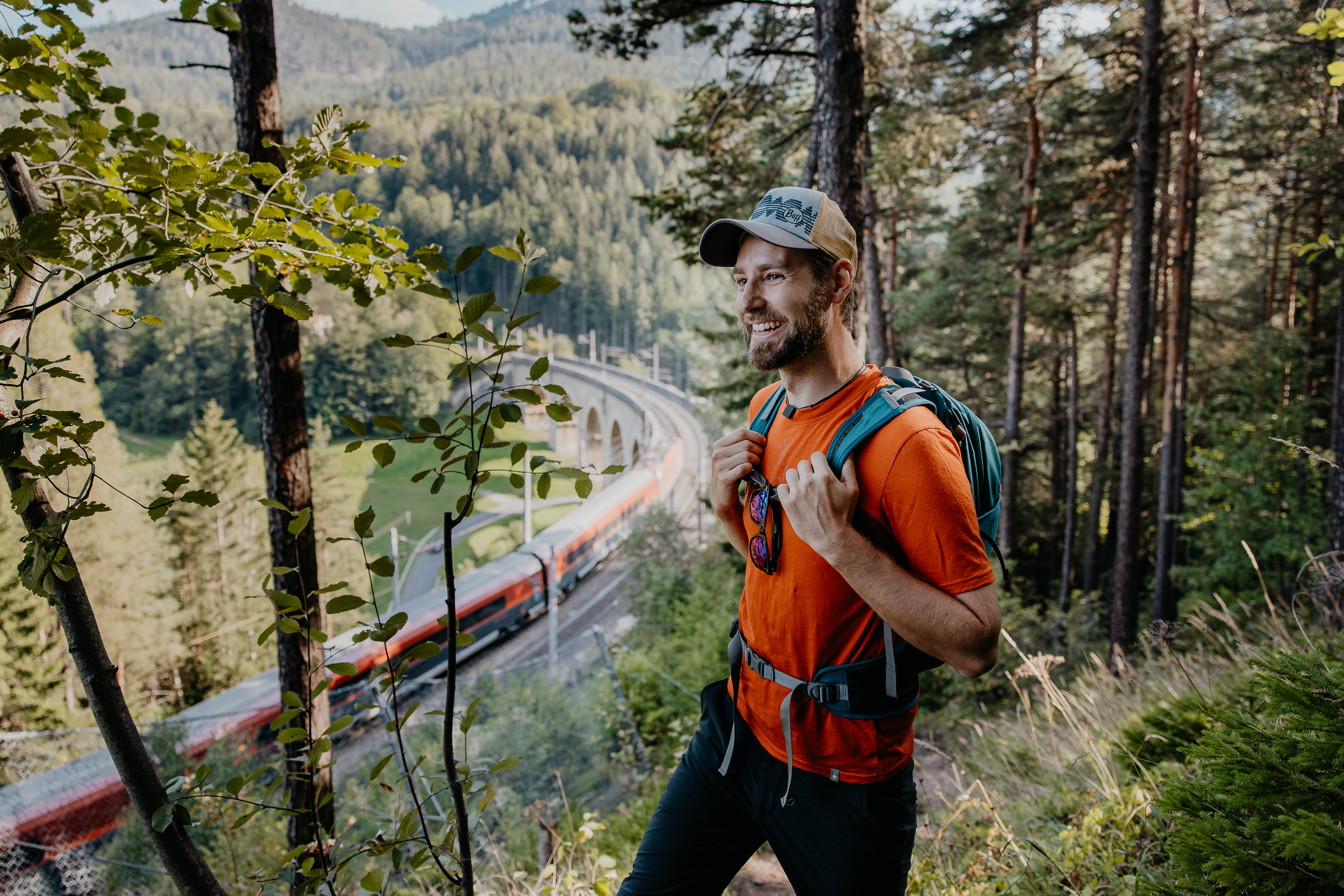 鉄道ハイキング道を歩くトレッカーと列車